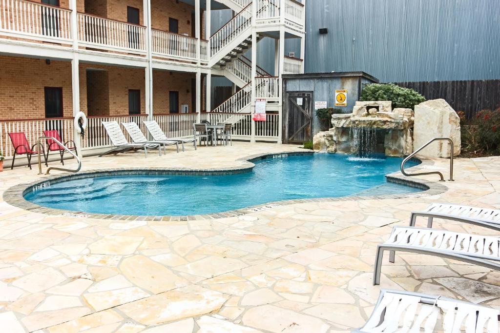 a swimming pool with a fountain in a courtyard at The Village at Gruene in New Braunfels