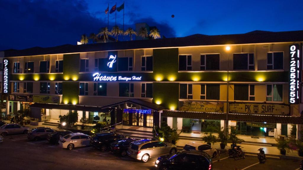 a hotel with cars parked in front of it at night at 7 Heaven Boutique Hotel in Pasir Gudang