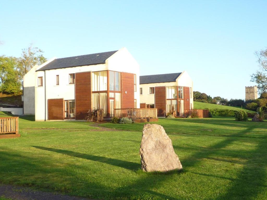 a large rock sitting in the grass in front of a house at Castle Quay Holiday Homes in Kinsale