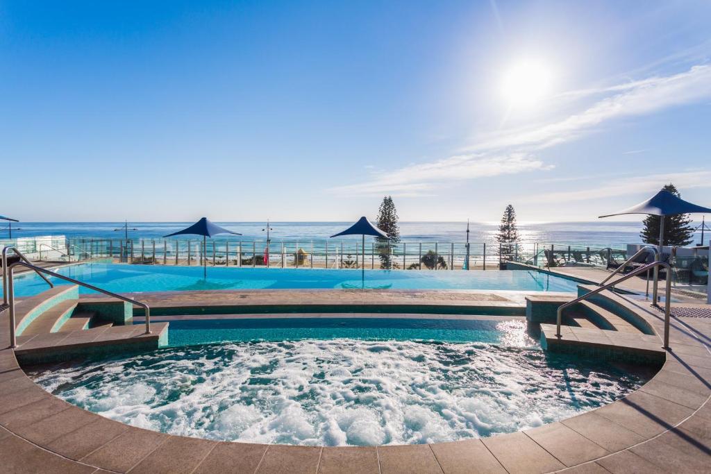 a swimming pool with the ocean in the background at Holiday Holiday Soul Apartments in Gold Coast