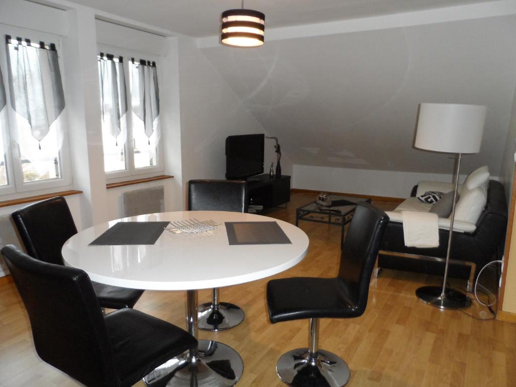 une salle à manger avec une table et des chaises blanches dans l'établissement Residence Rokia, à Royat