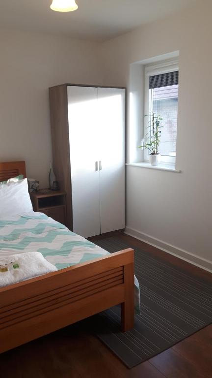 Schlafzimmer mit einem Bett mit einem Spiegel und einem Fenster in der Unterkunft Lavi's house-East Milton Keynes in Milton Keynes