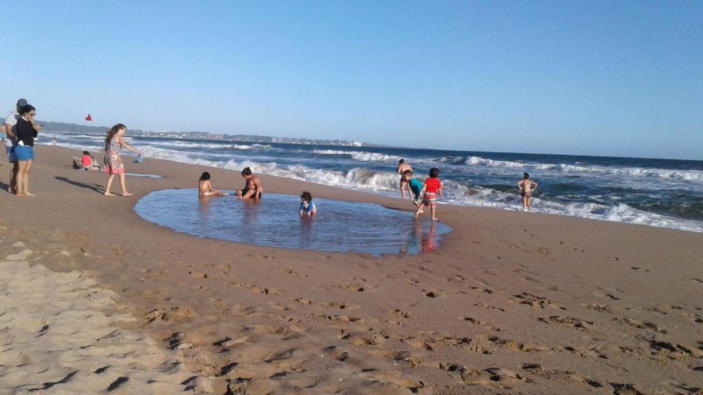 un grupo de personas jugando en el agua en la playa en Casa en la playa, en Maldonado