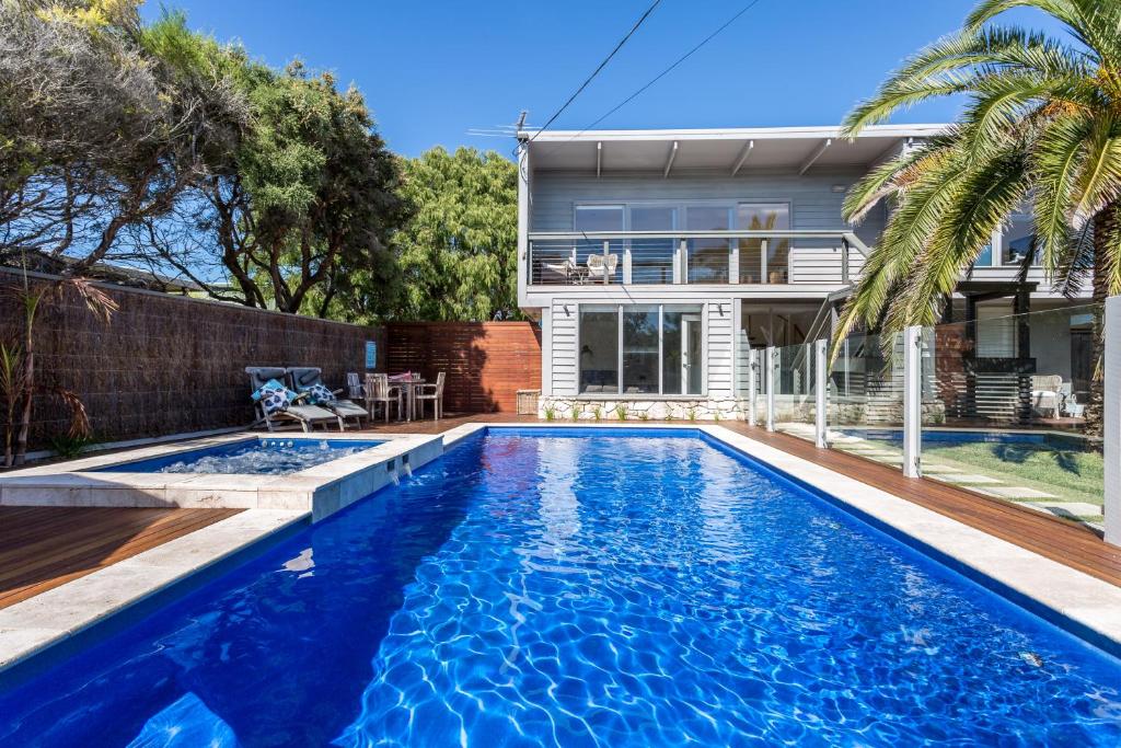 a swimming pool in front of a house at Front Beach House in Blairgowrie