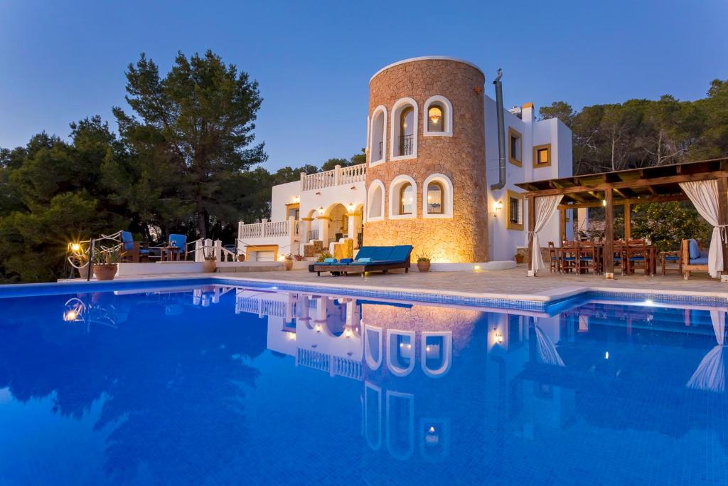 une villa avec une piscine la nuit dans l'établissement Villa Can Señora, à Sant Antoni de Portmany