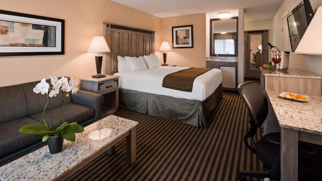 une chambre d'hôtel avec un lit et un canapé dans l'établissement Best Western Americana Inn, à San Ysidro