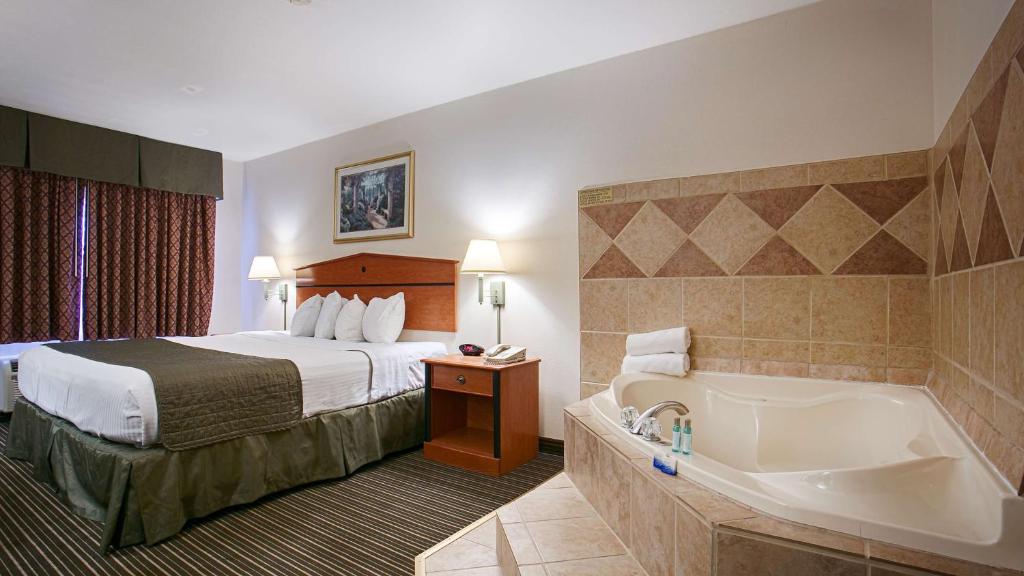 a hotel room with a bed and a bath tub at Best Western J. C. Inn in Junction City