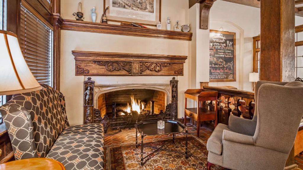 a living room with a fireplace and a chair at Best Western Premier Mariemont Inn in Cincinnati