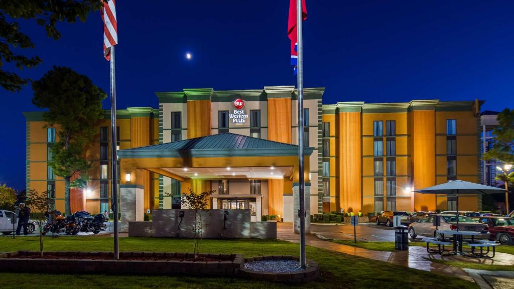 un edificio amarillo con dos banderas delante en Best Western Plus Galleria Inn & Suites, en Memphis