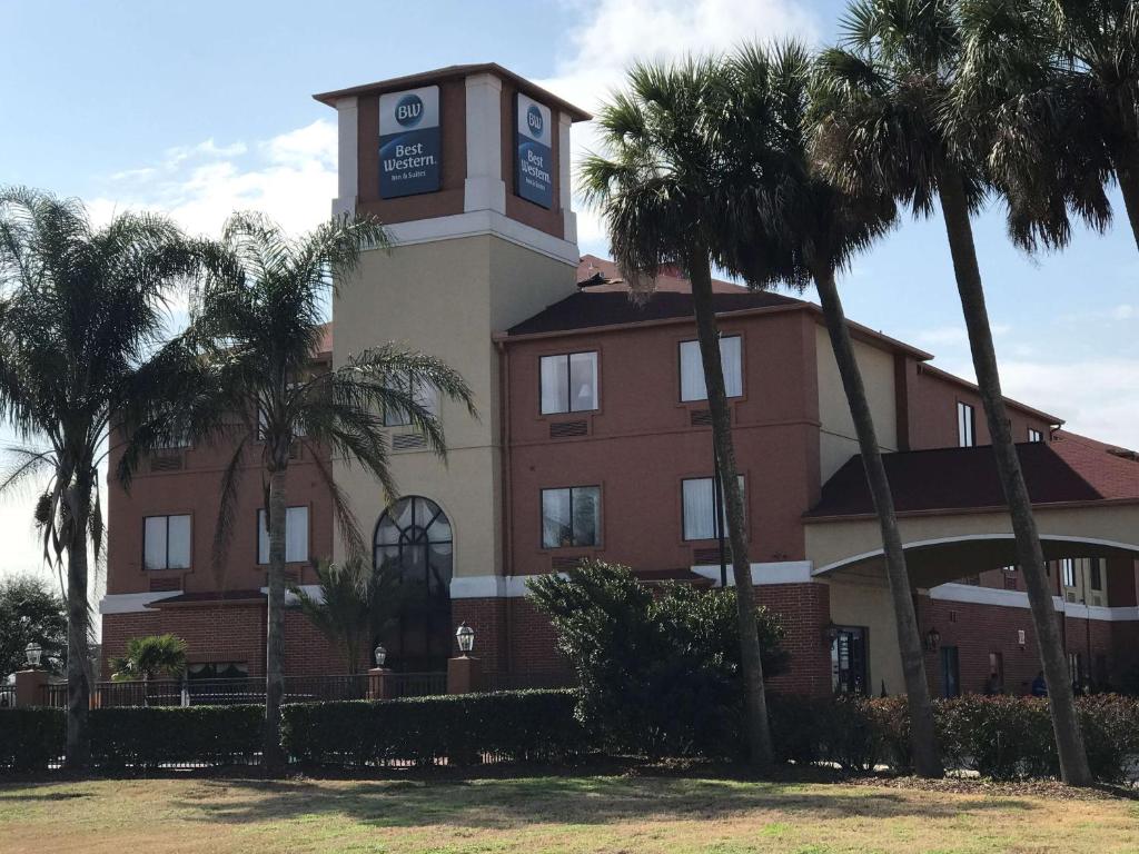 un bâtiment doté d'une tour d'horloge avec des palmiers dans l'établissement Best Western Orange Inn & Suites, à Orange