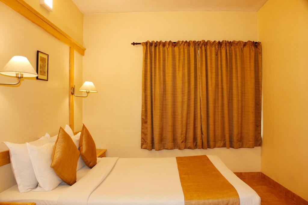Postel nebo postele na pokoji v ubytování Kodai Resort Hotel, Kodaikanal