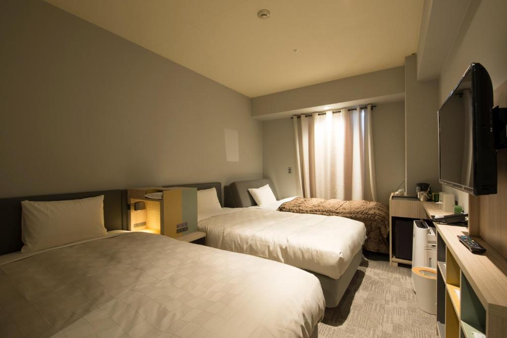 Postel nebo postele na pokoji v ubytování HOTEL FUKURACIA OSAKA-BAY