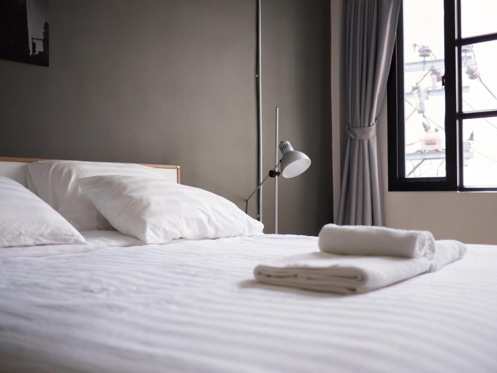 un letto bianco con due asciugamani sopra di Pann Residence a Bangkok
