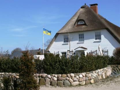 ニーブルムにあるHausteil Webstube Föhrの石垣上の旗のある家