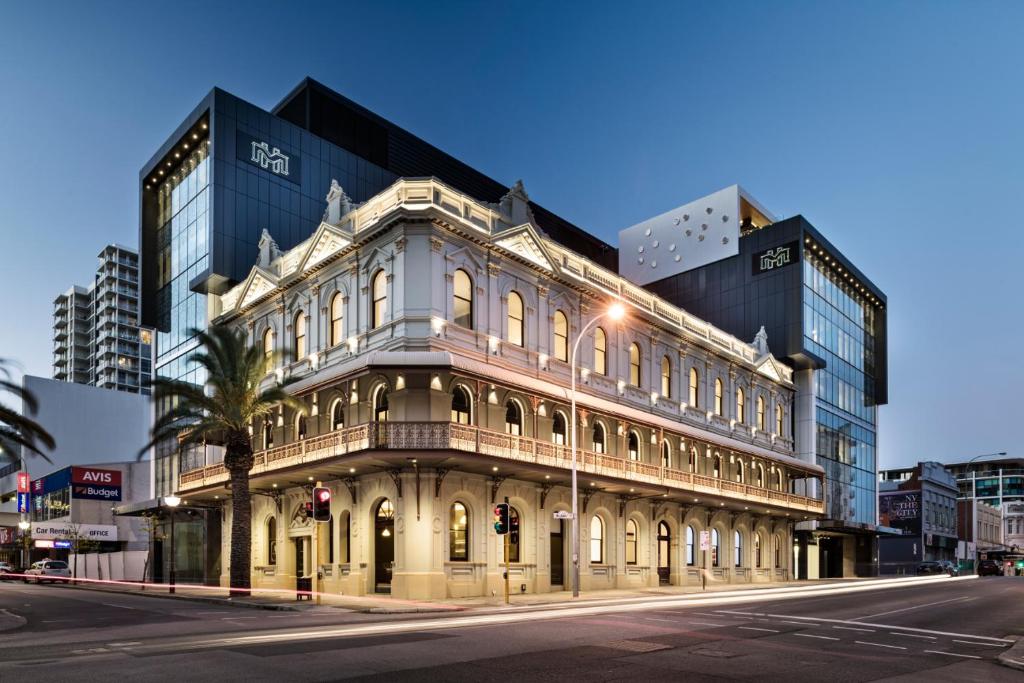a large building with a clock on the front of it at The Melbourne Hotel in Perth