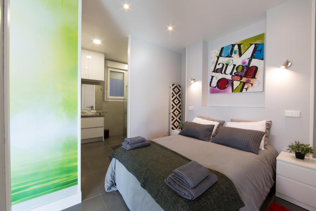- une chambre avec un lit et une peinture murale dans l'établissement WindRose 2, à Madrid