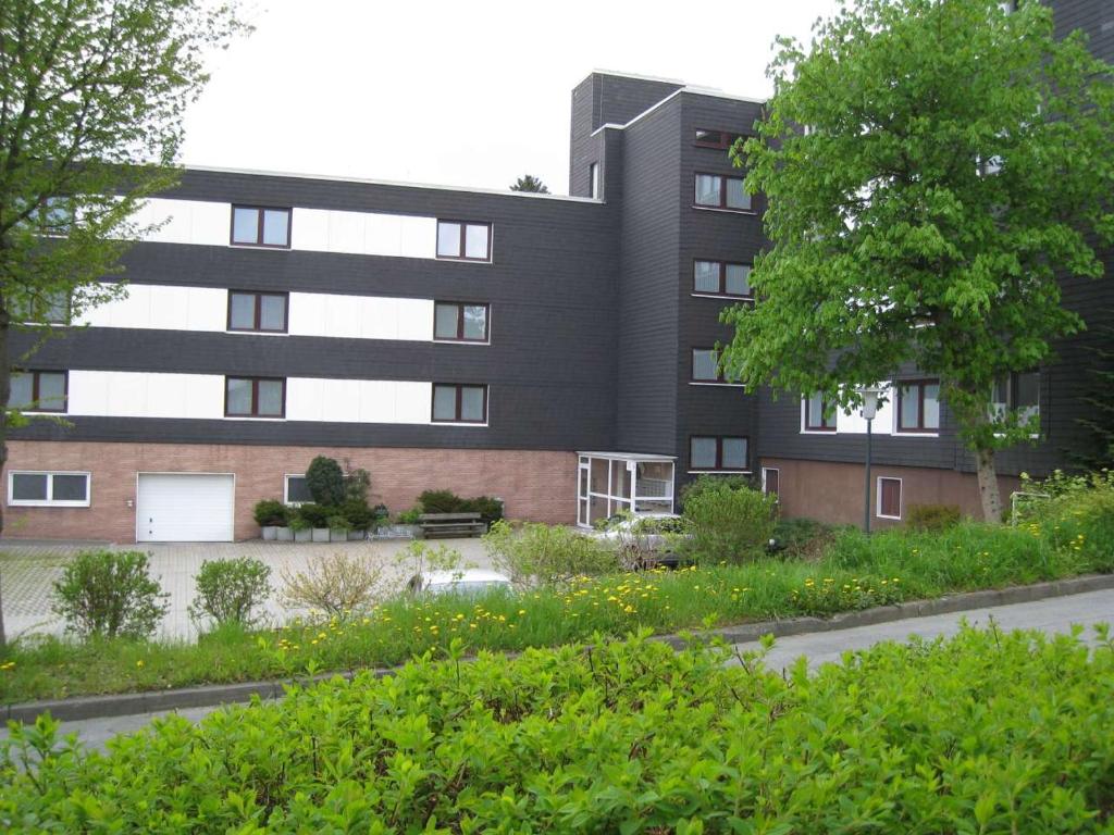 a black building with a garden in front of it at Ferienappartement Feldstrasse in Winterberg