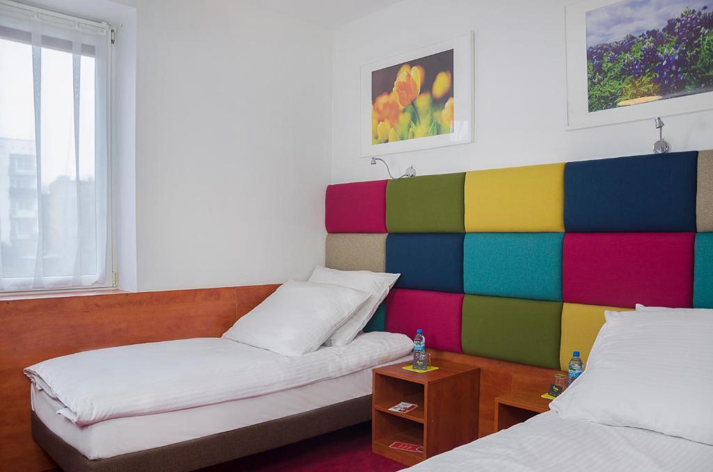 ソスノヴィエツにあるeuroHOTEL Sosnowiec Kazimierzのベッド2台が備わるカラフルな壁の客室です。