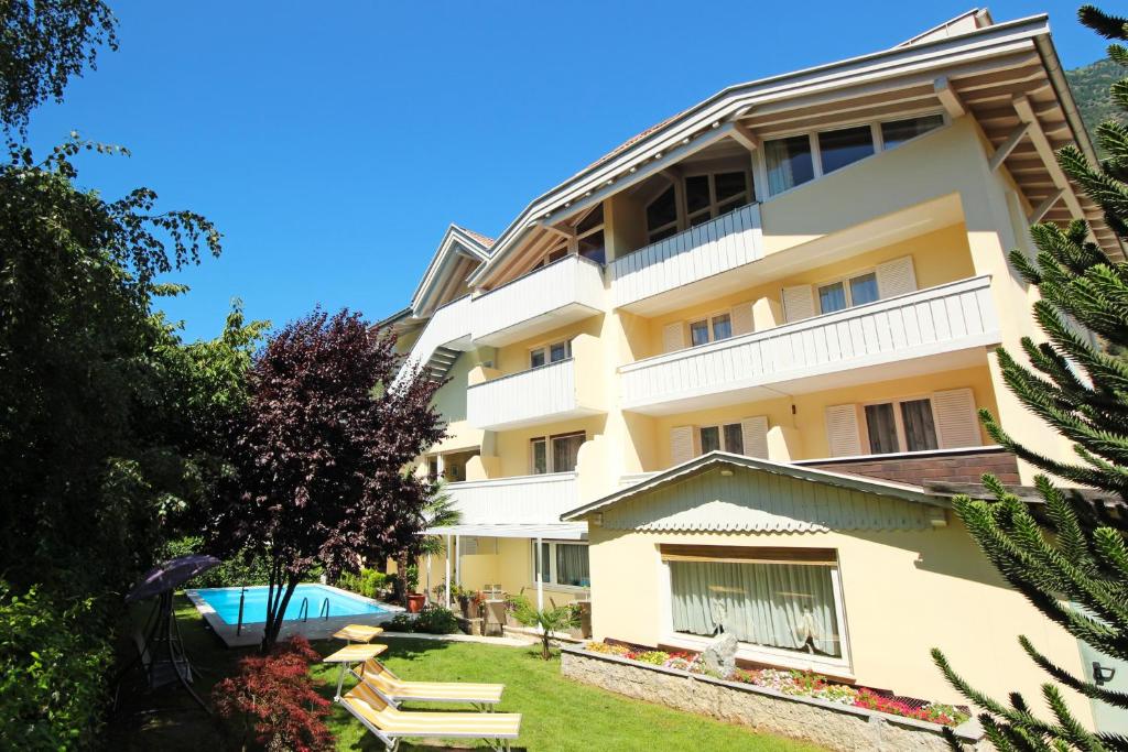 a large apartment building with a yard with benches at Garni Sonnblick in Naturno