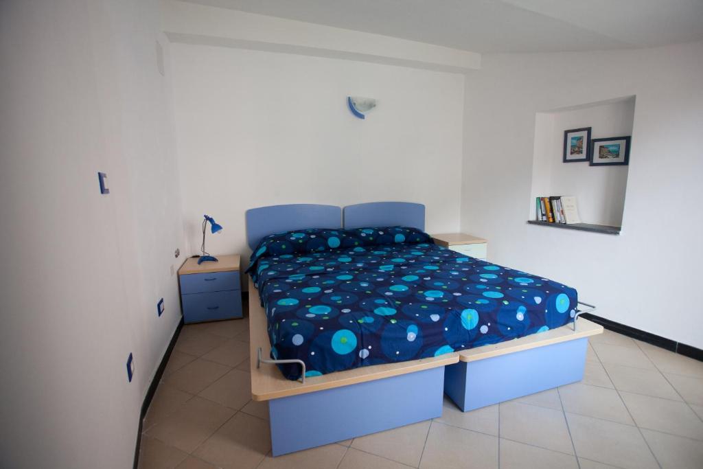 a bedroom with a bed with a blue comforter at Scorci Di Mare in Riomaggiore