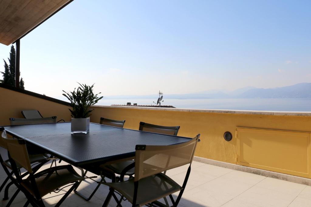 トッリ・デル・ベーナコにあるA Casa di Emy, Lago di Gardaのテーブルと椅子、海の景色を望むバルコニー