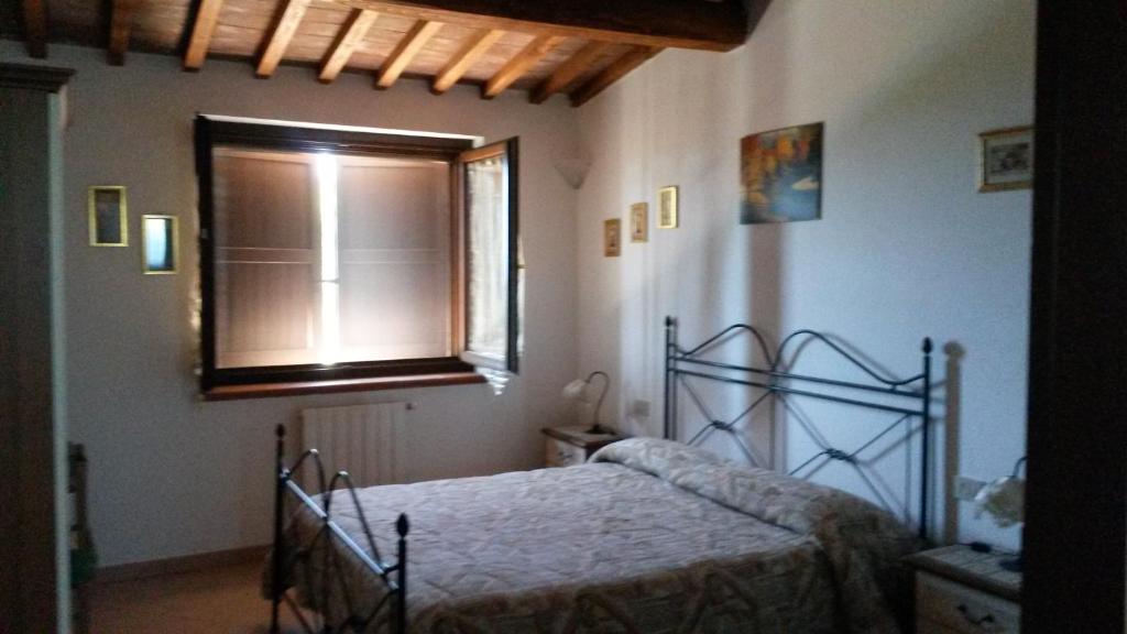 sypialnia z łóżkiem i oknem w obiekcie Podere Mammoleta w mieście Fattoria la Marsiliana