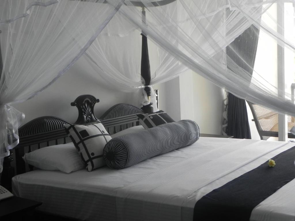 a bedroom with a bed with a canopy at Amanda Beach Villas in Unawatuna