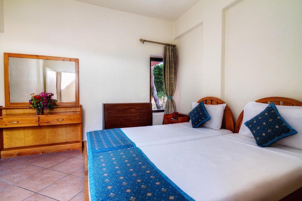 1 Schlafzimmer mit 2 Betten, einem Spiegel und einer Kommode in der Unterkunft Eagles Paradise Abu Soma Resort in Hurghada