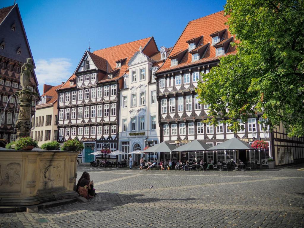 un gruppo di edifici con tavoli e sedie su strada di Van der Valk Hotel Hildesheim a Hildesheim