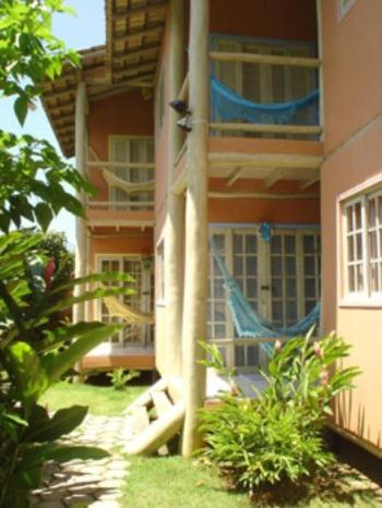 a house with a hammock on the side of it at Chalés Musa de Maresias in Maresias