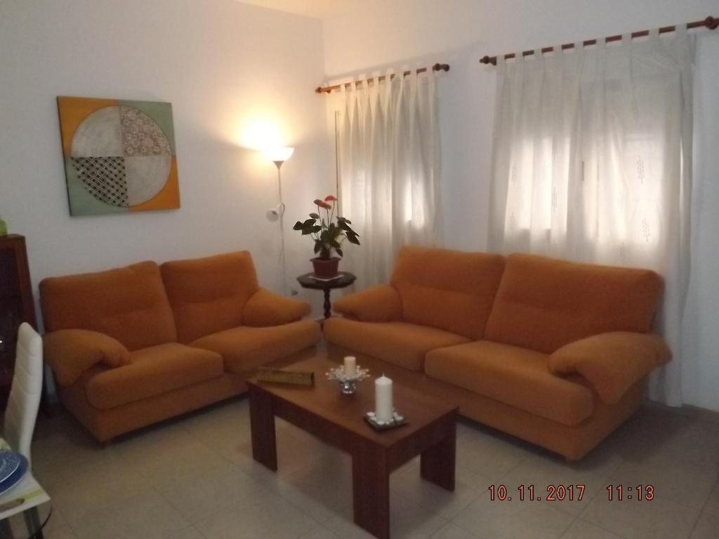 フエンヒロラにあるtrinidad 63 bajo Aのリビングルーム(オレンジ色のソファ2台、コーヒーテーブル付)