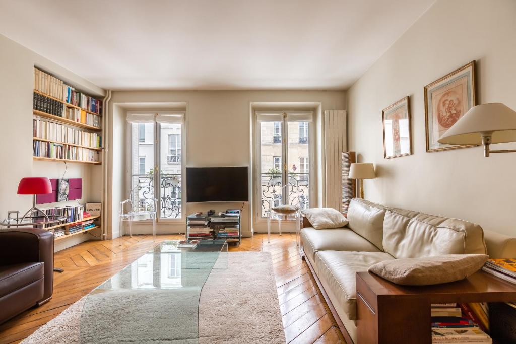 a living room with a couch and a tv at Veeve - Pompidou Hideaway in Paris