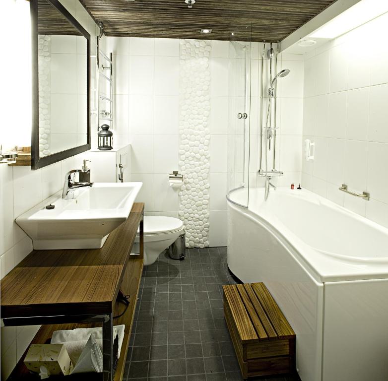 a bathroom with a sink and a tub and a toilet at Santa's Hotel Santa Claus in Rovaniemi