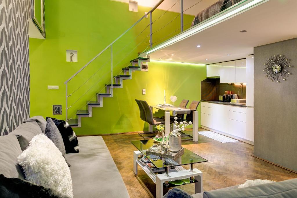 - un salon avec un mur vert et un escalier dans l'établissement Feel Different Apartment, à Budapest