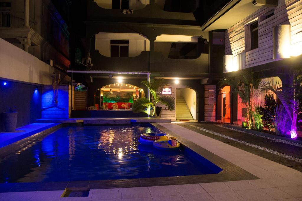 a swimming pool in the middle of a house at night at Le Pôle in Grand Baie