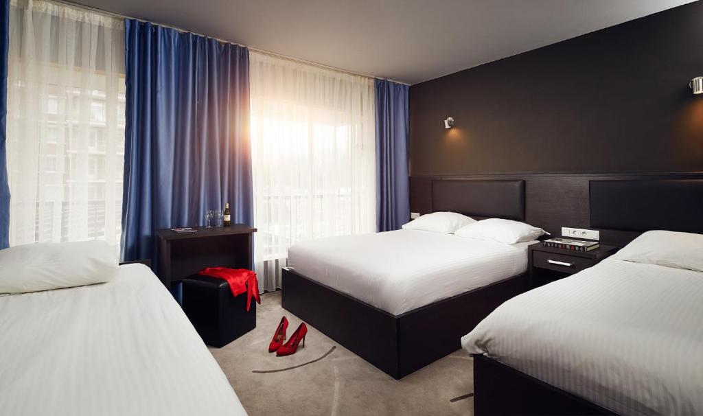Postel nebo postele na pokoji v ubytování Belfort Hotel