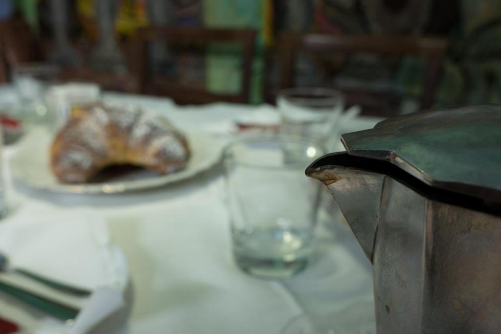 una mesa con un plato de comida y un vaso de agua en Rodoflor Rooms, en Castellammare di Stabia
