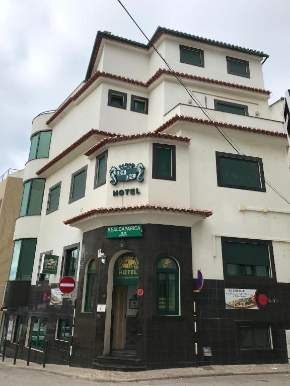 a large white building with a sign on it at Real Caparica Hotel in Costa da Caparica