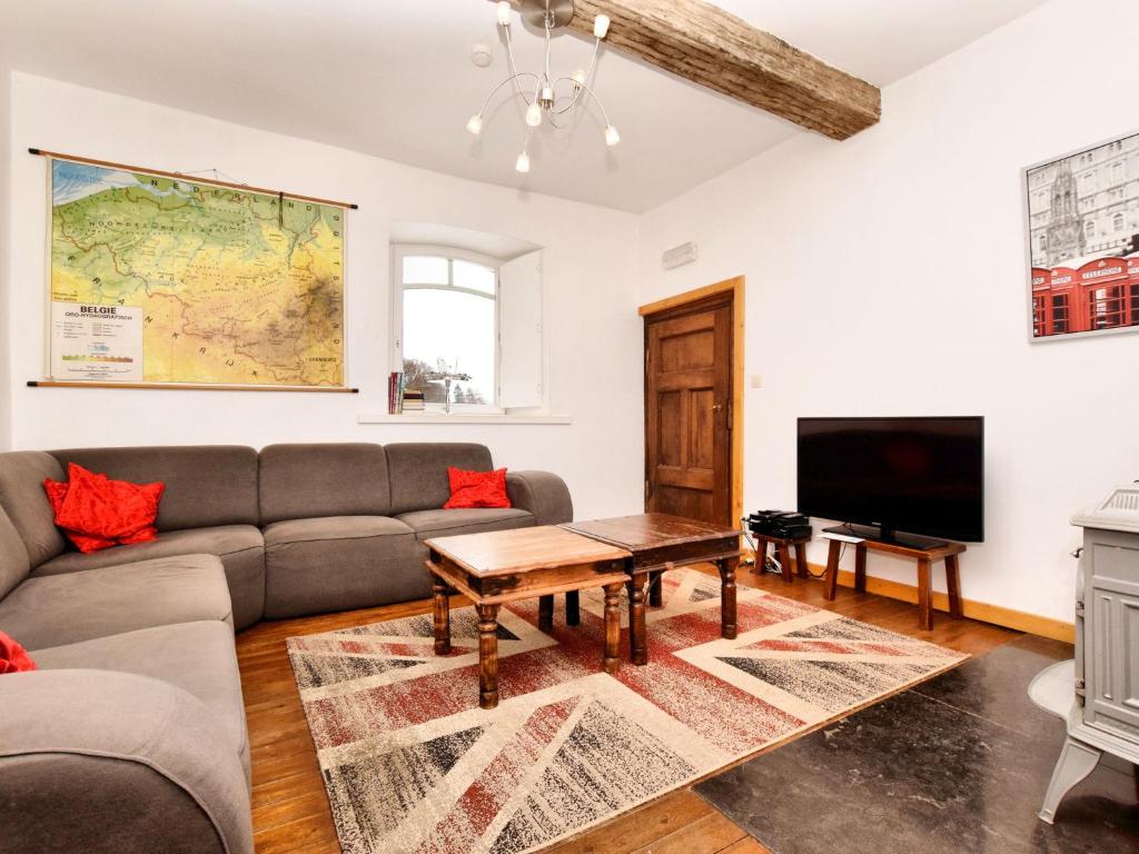 uma sala de estar com um sofá e uma televisão em Welcome to this holiday home ideal for groups em Robertville