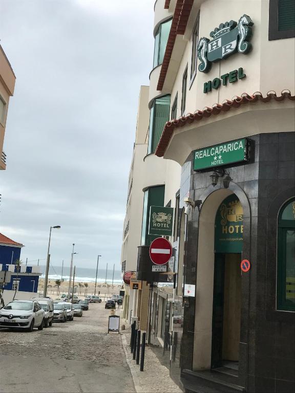 a street with cars parked on the side of a building at Real Caparica Hotel in Costa da Caparica
