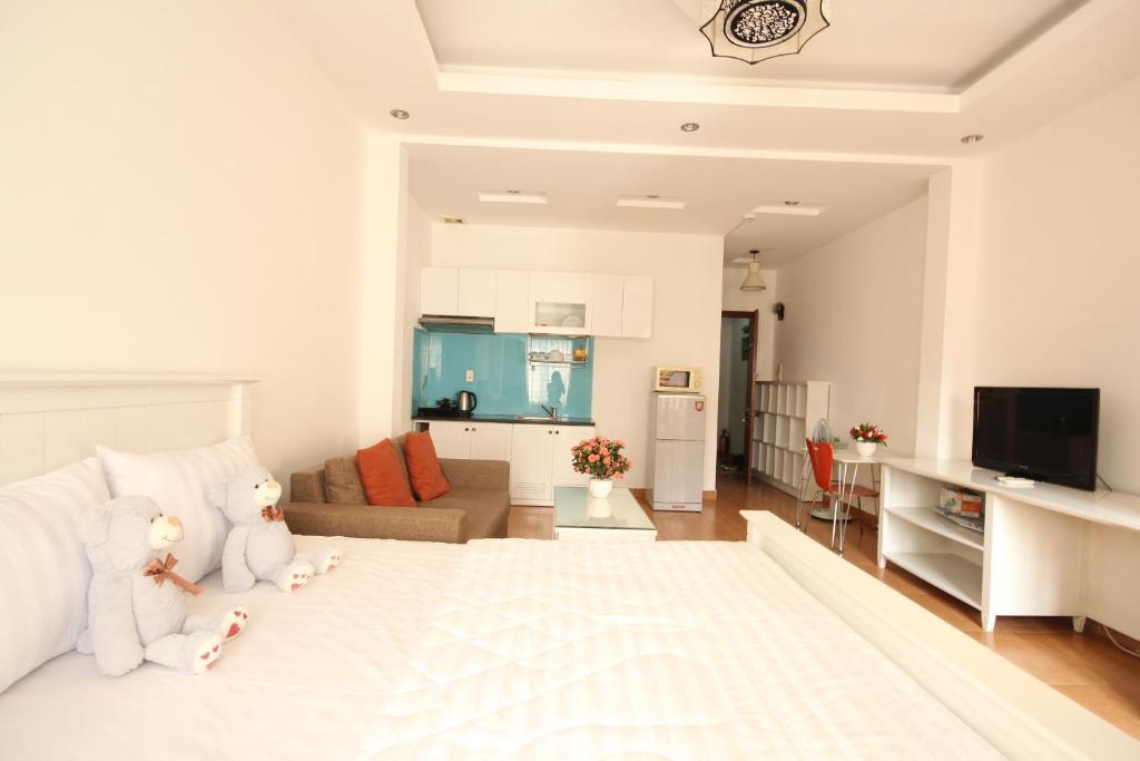 un dormitorio blanco con dos ositos de peluche sentados en una cama en Smiley Apartment 3, en Ho Chi Minh