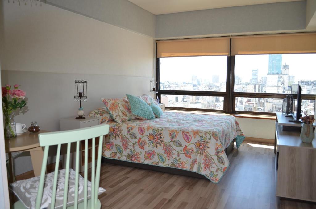 una camera da letto con un letto e una grande finestra di Torre Obelisco a Buenos Aires
