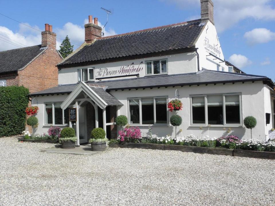 a white building with flowers in front of it at The Parson Woodforde in Norwich