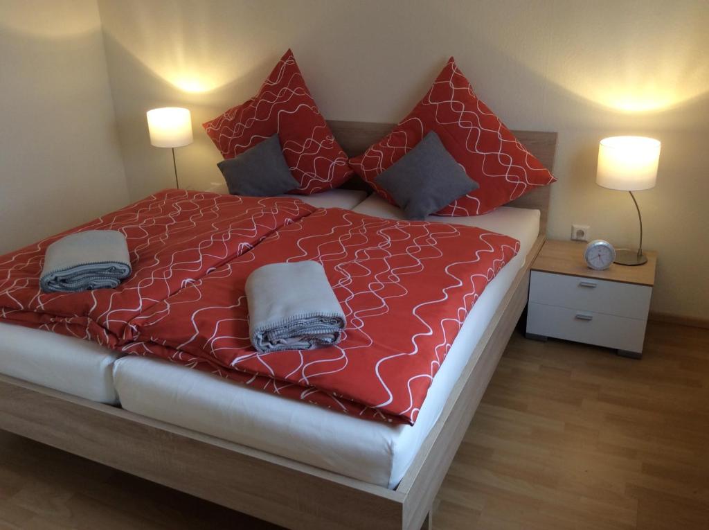 - une chambre avec un lit doté de draps et d'oreillers rouges dans l'établissement Appartement am Universitätscampus, à Heidelberg