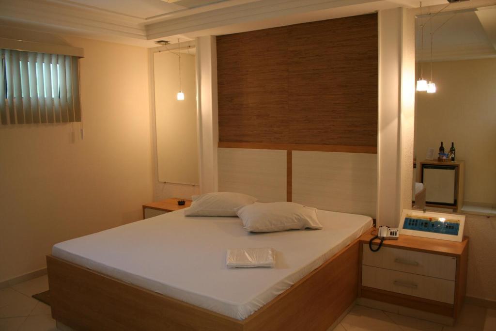 a bedroom with a large white bed with a window at Top´s Motel (Adult Only) in Jacareí