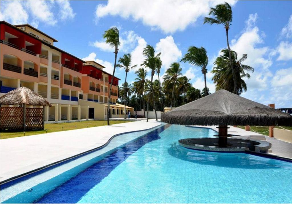uma piscina com guarda-sol e um edifício em Costa Brava Praia Hotel em Lucena