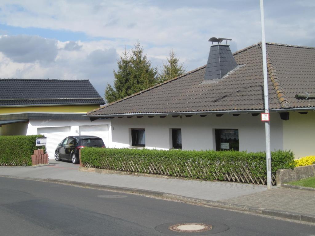 a white house with a black roof and a car at Haus Alexander in Mechernich