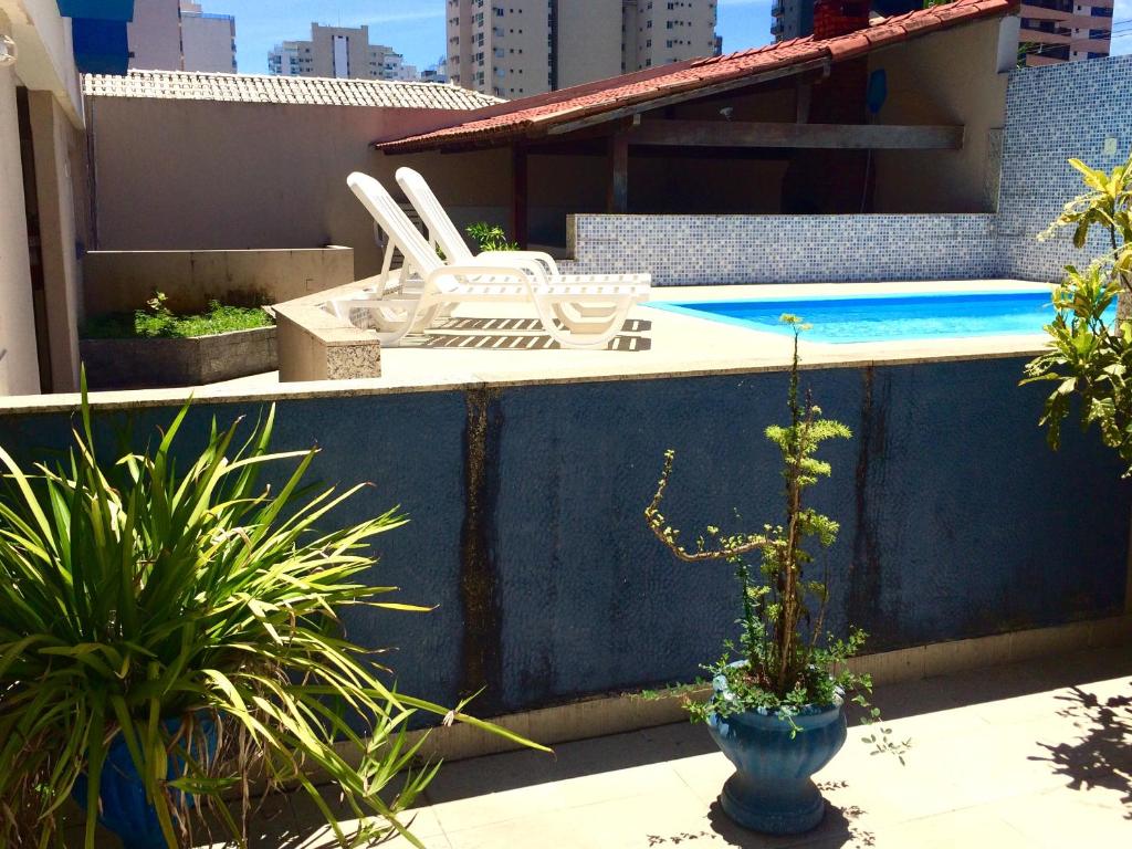 a white vase sitting on top of a table next to a pool at Hotel Marlin Azul in Vila Velha