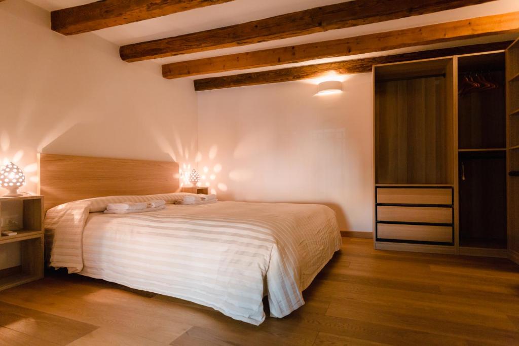 ボローニャにあるHistorical and Luxury Apartmentのウッドフロアのベッドルーム1室(大きな白いベッド1台付)