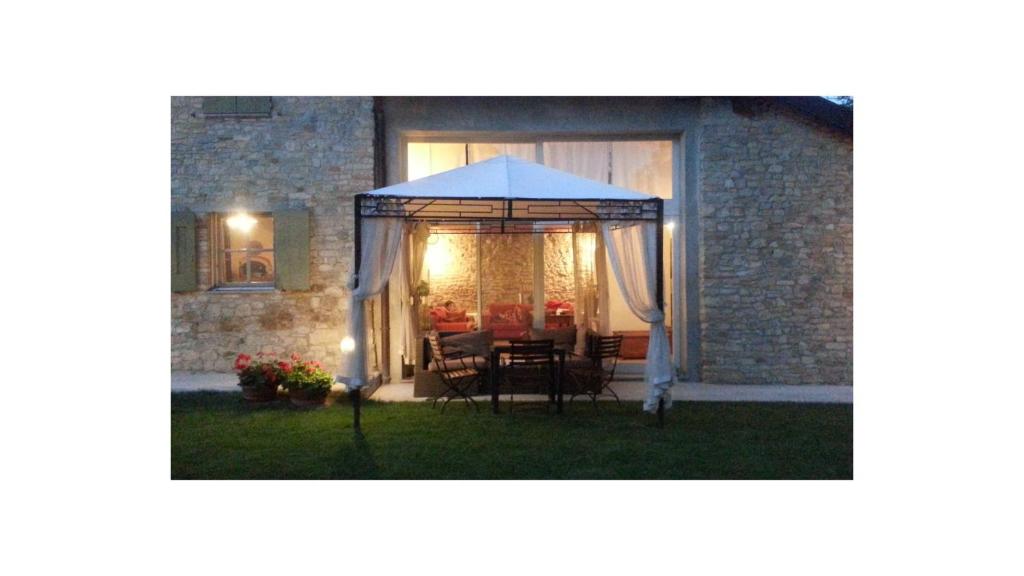 a table and chairs under an umbrella in a yard at La Davana Parma in Salsomaggiore Terme